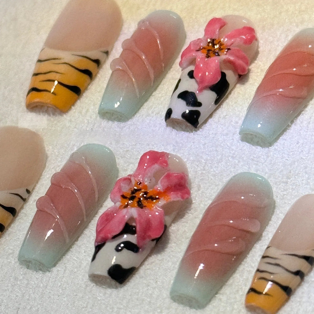 Set of false nails with zebra stripe, lily flower, and leopard print hand carving designs in long, wear-resistant style.