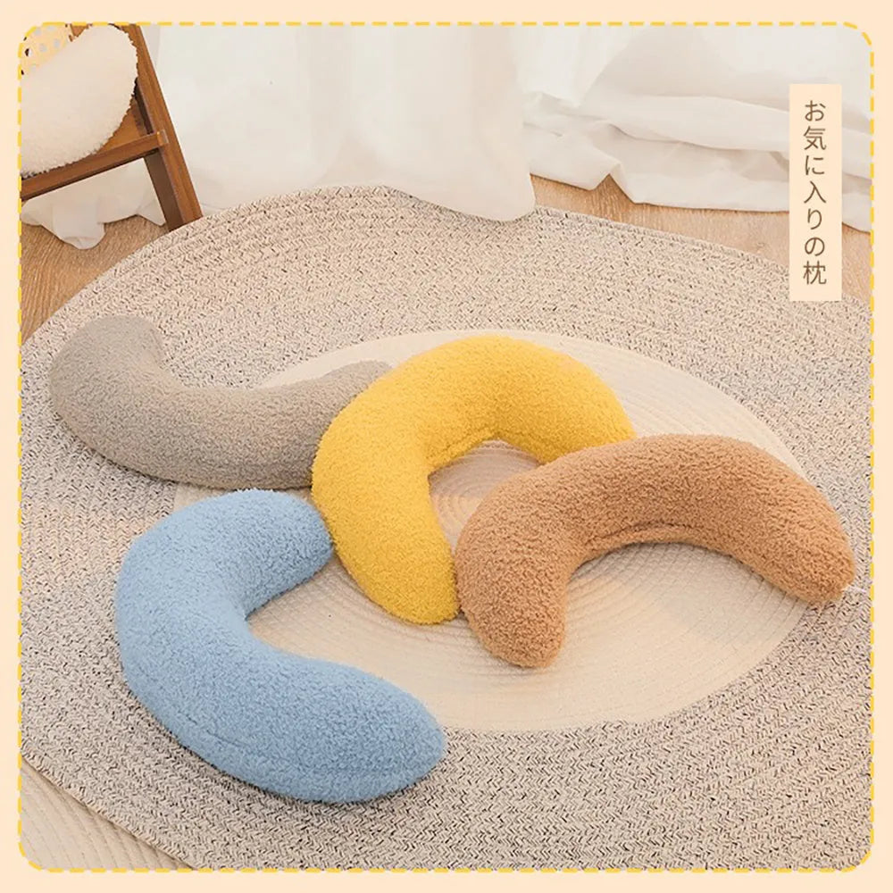 Blue U-shaped cat pillow with an integrated adjustable fabric collar on a grey blanket