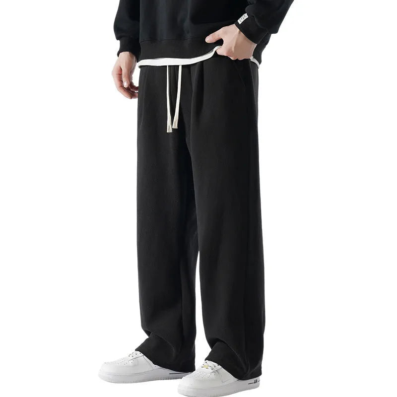 Men's double-sided polar fleece sports trousers in apricot, showing loose fit and drawstring waist.