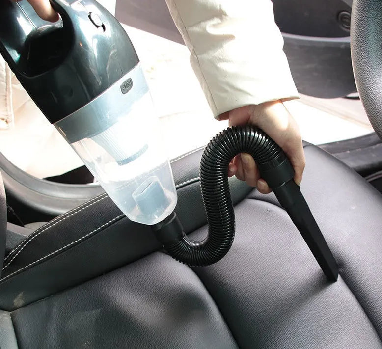 Orange 12V handheld car vacuum cleaner with nozzle attached, showing compact design.