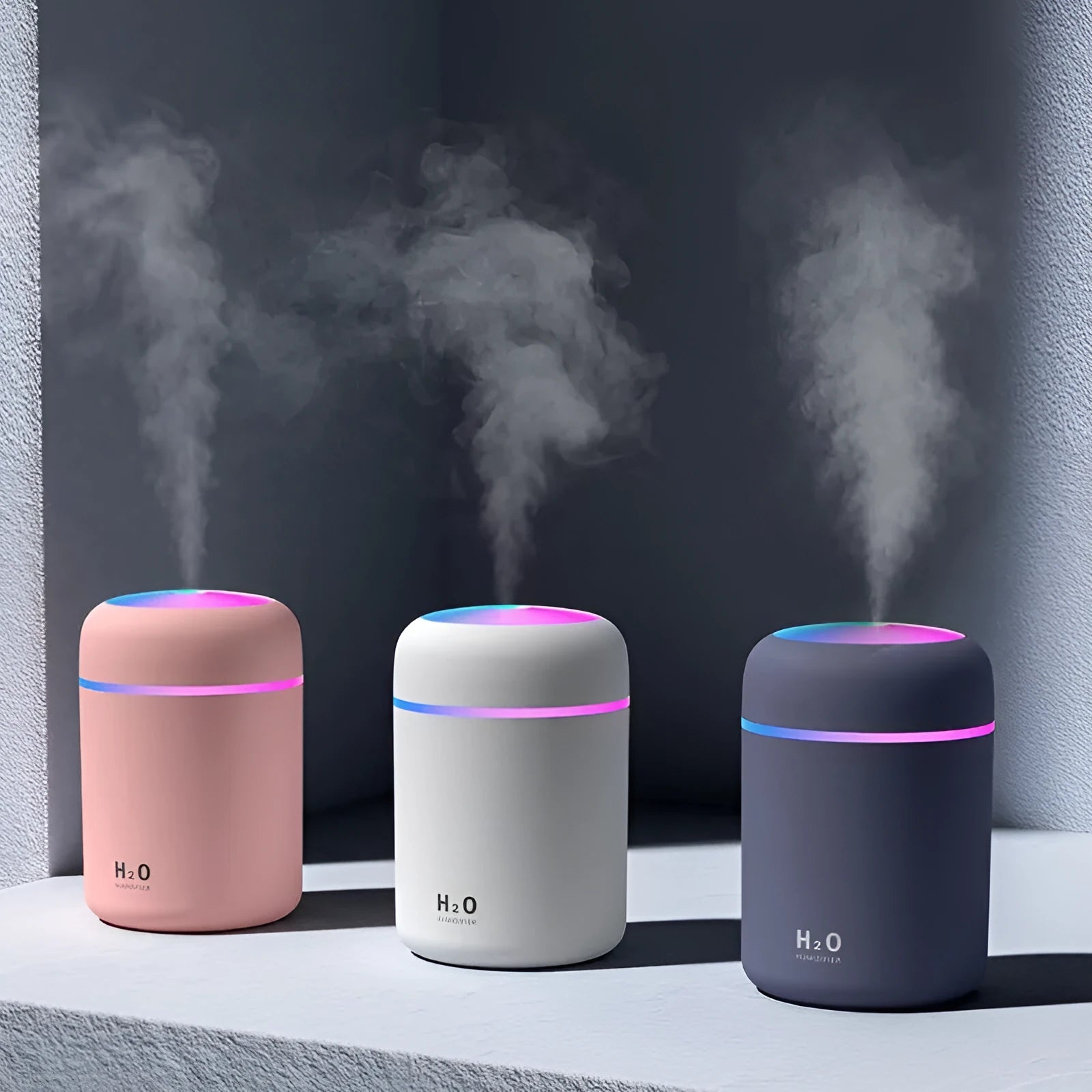 Pink USB desktop humidifier with colourful LED lights and 300ml water tank on wooden desk