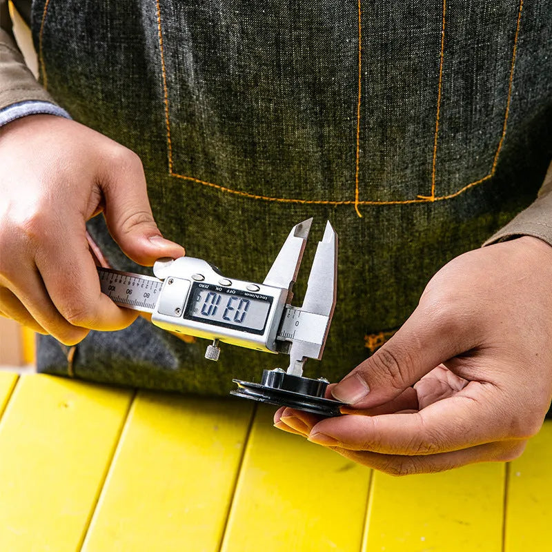 Deli stainless steel digital vernier caliper with 0.01mm resolution and LCD display on workshop surface