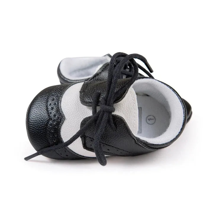 Vintage-style soft-soled baby shoes in synthetic leather with plain pattern design