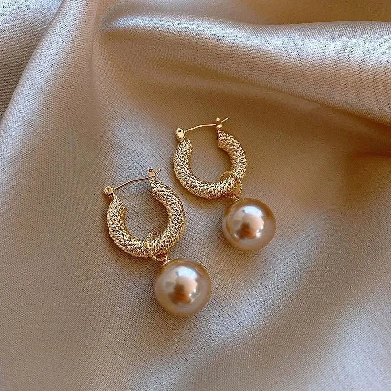 A pair of simple geometric rose-inspired earrings for women, made from electroplated copper, shown in one of the available colour types.