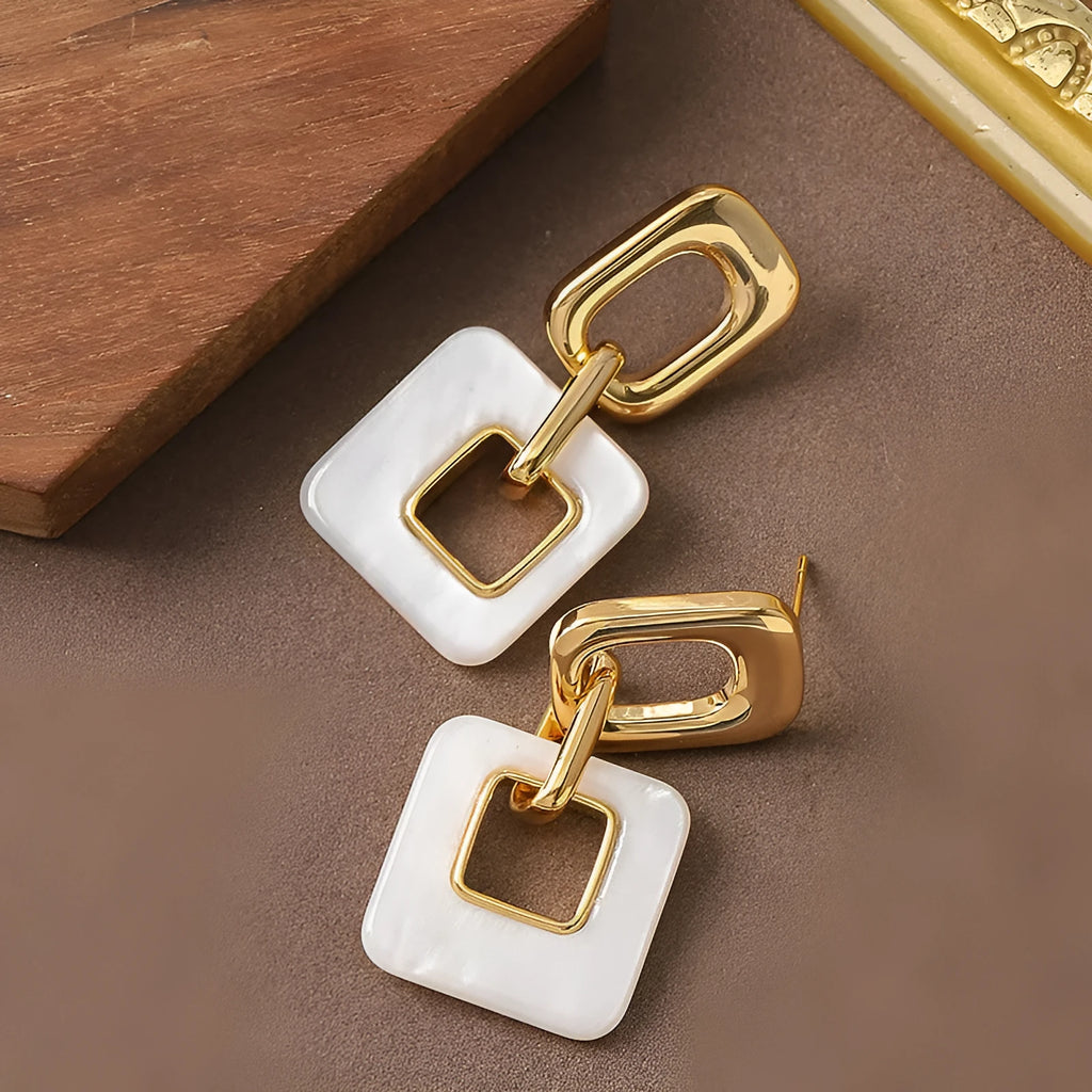 A pair of hollow geometric square earrings with chamfered corners in an electroplated copper finish.