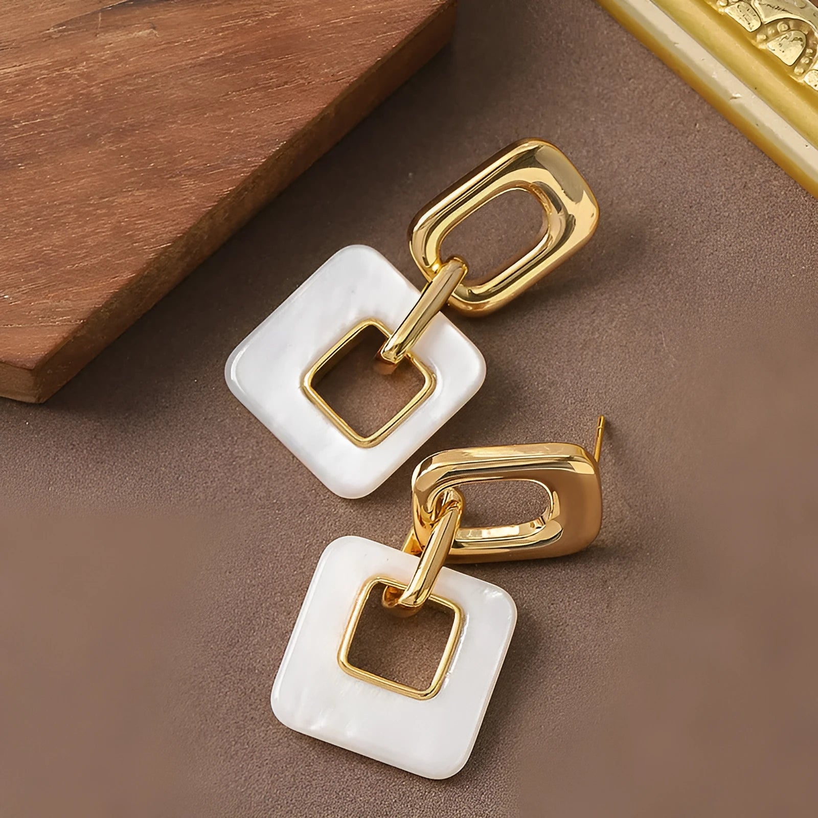 A pair of hollow geometric square earrings with chamfered corners in an electroplated copper finish.