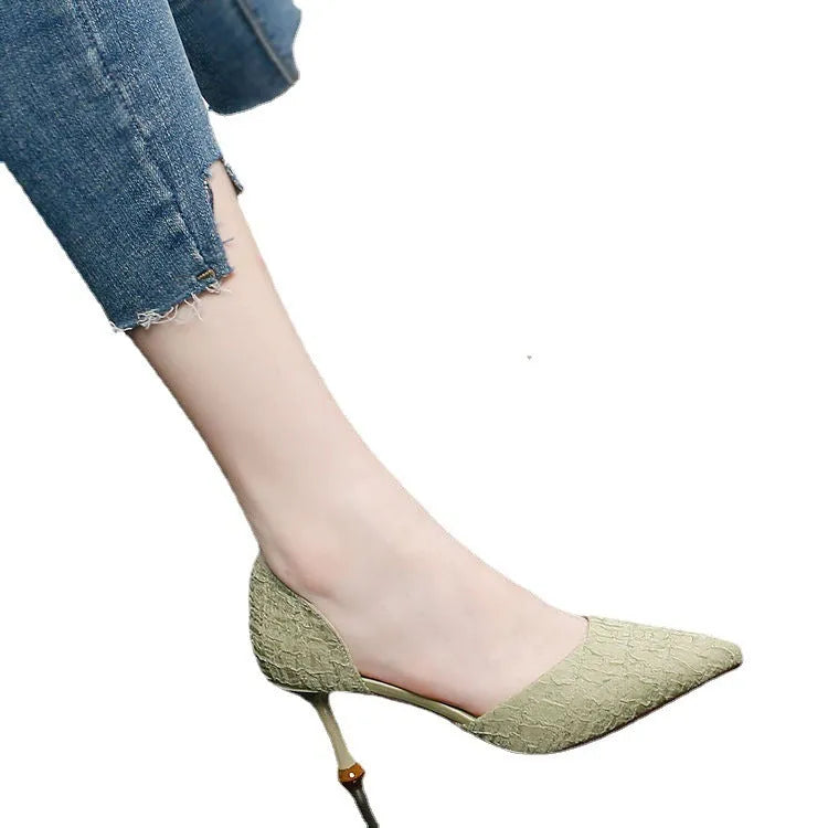 Women's black pointed stiletto high heels with a thin heel on a plain background.