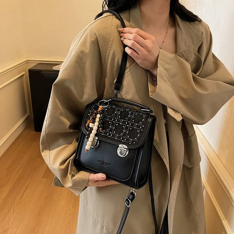 Small square PU leather messenger backpack for women with texture finish in black colour