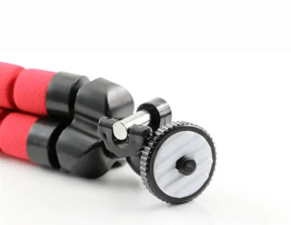 Black flexible octopus tripod with wrapped legs next to a smartphone, showing its 18cm size and universal screw mount.