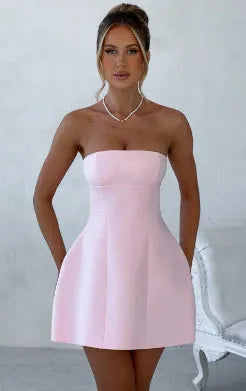 A woman wearing a solid colour backless A-line tube dress with a high waist and short skirt.