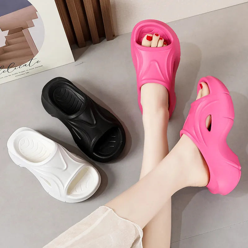 Women's white EVA slippers with a thick sole on a sandy beach background
