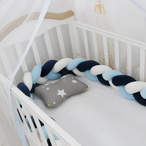 Braided knot crib bumper in spandex velvet, shown bending to fit a white wooden cot.
