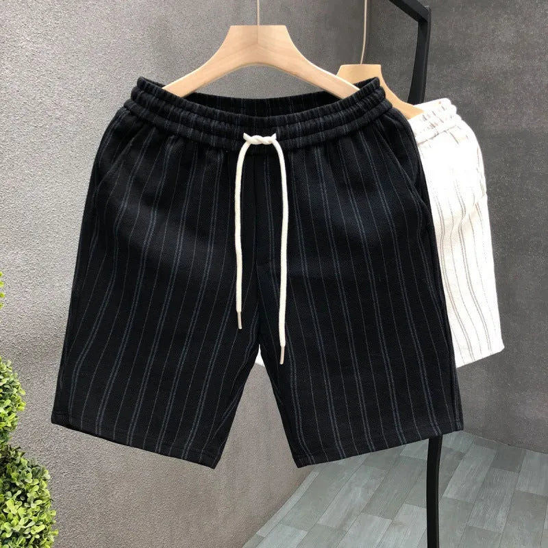 Men's black and white striped fleece-lined casual shorts with an elastic waistband on a grey background.
