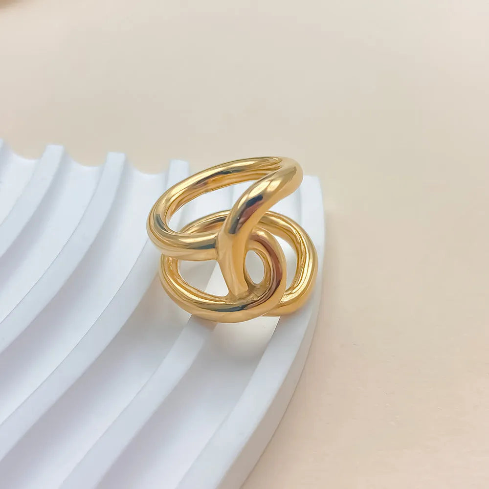 Adjustable stainless steel ring with knotted geometric design in gold or steel colour on finger