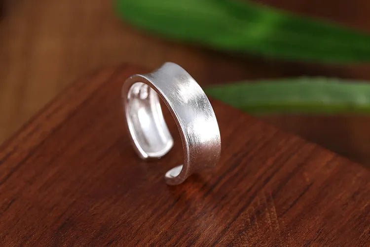 Open geometric ring in frosted sterling silver with an adjustable band.