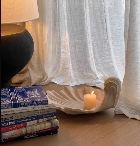 White resin simulation shell fruit plate ornament on a table.