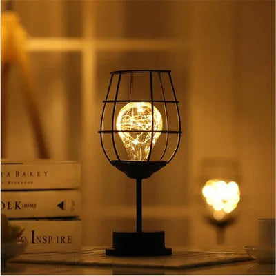Minimalist hollow iron table lamp in wine glass or bottle design with warm white LED light