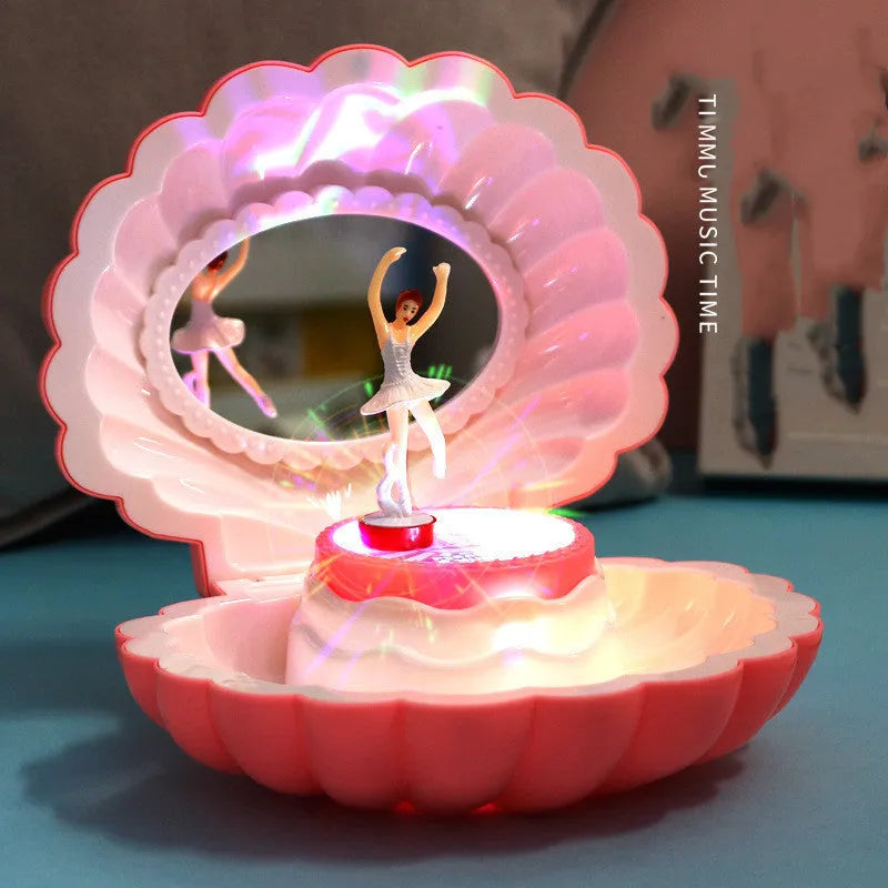 Plastic ballet girl music box in random colour, shows figure above shell, 160x130x155mm