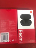 Redmi AirDots black true wireless earbuds next to their white charging case.