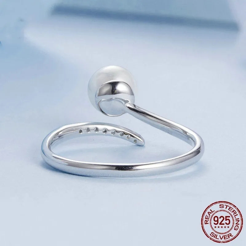 S925 sterling silver adjustable ring with a natural shell pearl on an open loop band.