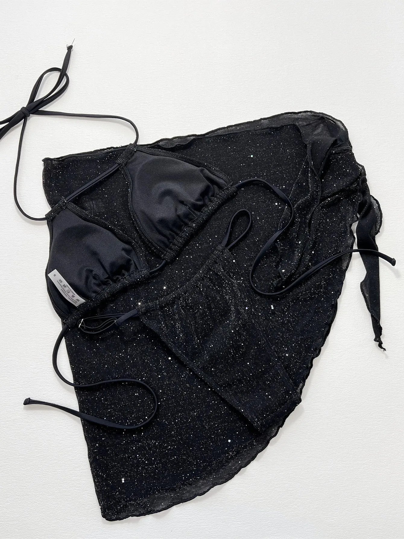 Black three-piece polyester bikini swimsuit set showing top and shorts.