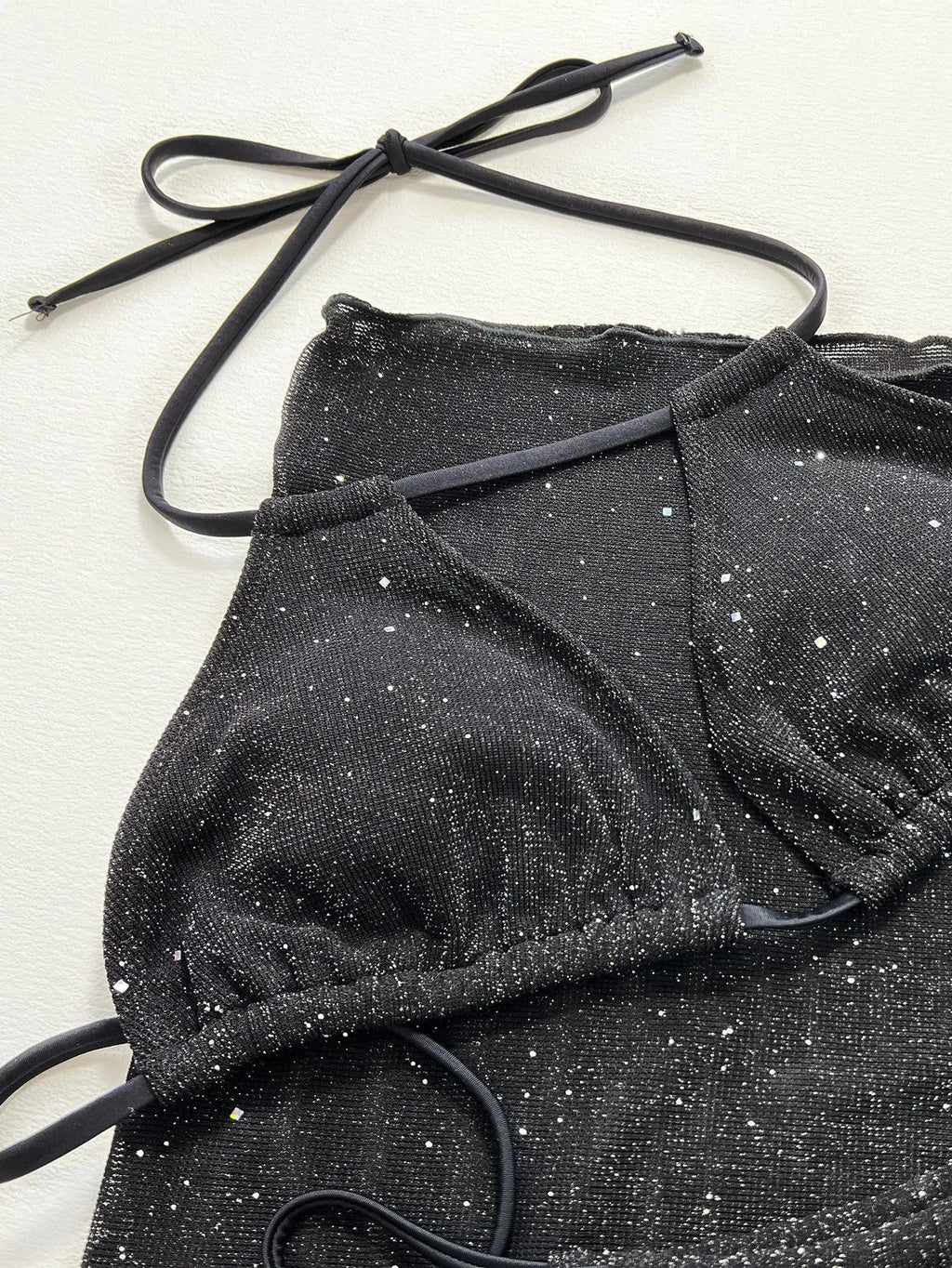 Black three-piece polyester bikini swimsuit set showing top and shorts.