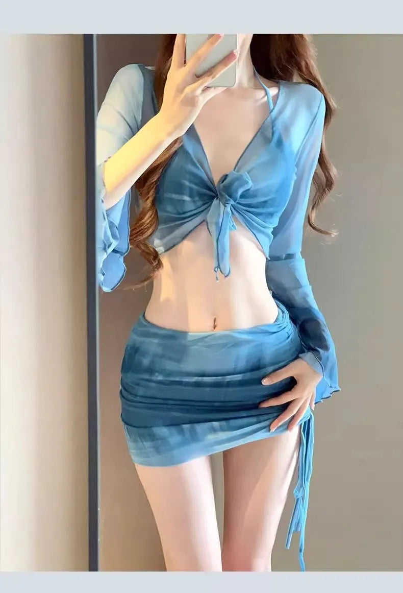 Women's blue four-piece bikini swimsuit set with high-waisted briefs, shirt, and skirt laid flat.