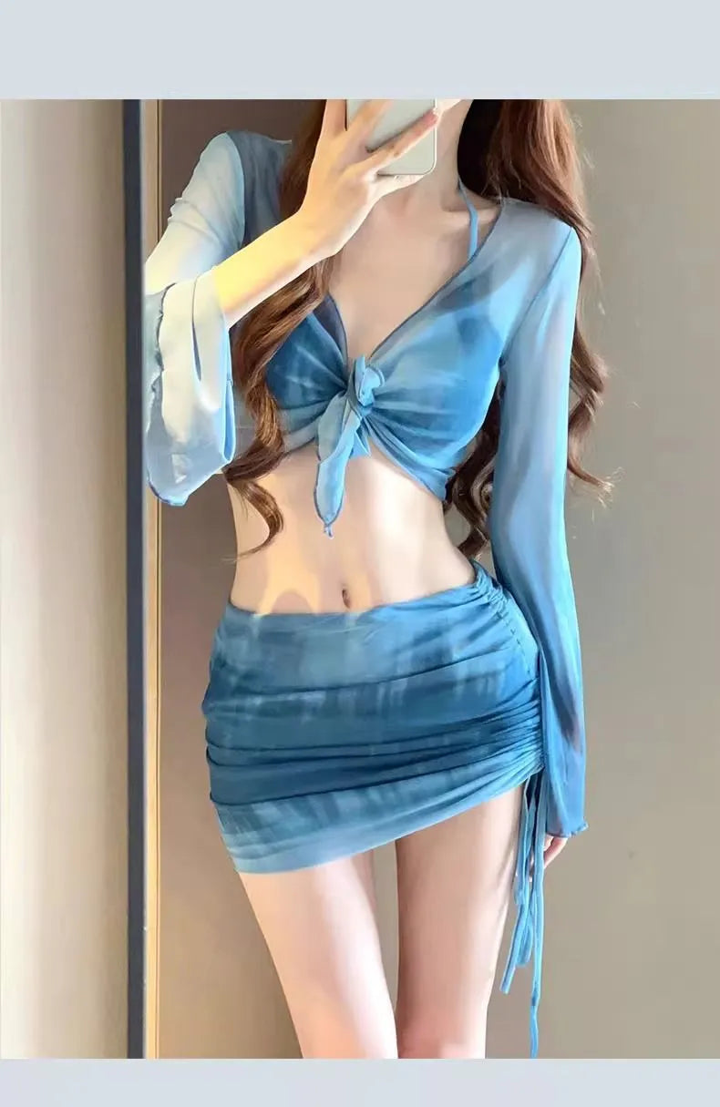 Women's blue four-piece bikini swimsuit set with high-waisted briefs, shirt, and skirt laid flat.