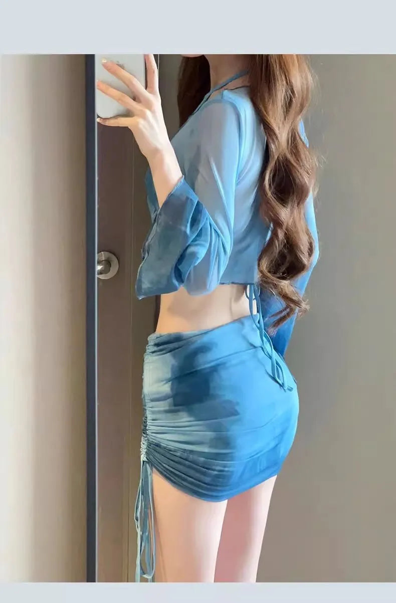 Women's blue four-piece bikini swimsuit set with high-waisted briefs, shirt, and skirt laid flat.