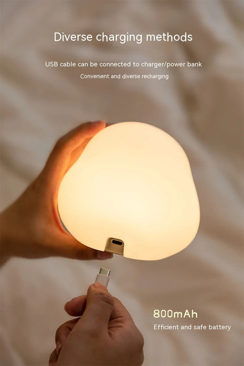 Cute duck-shaped silicone LED night lamp on a bedside table with warm light
