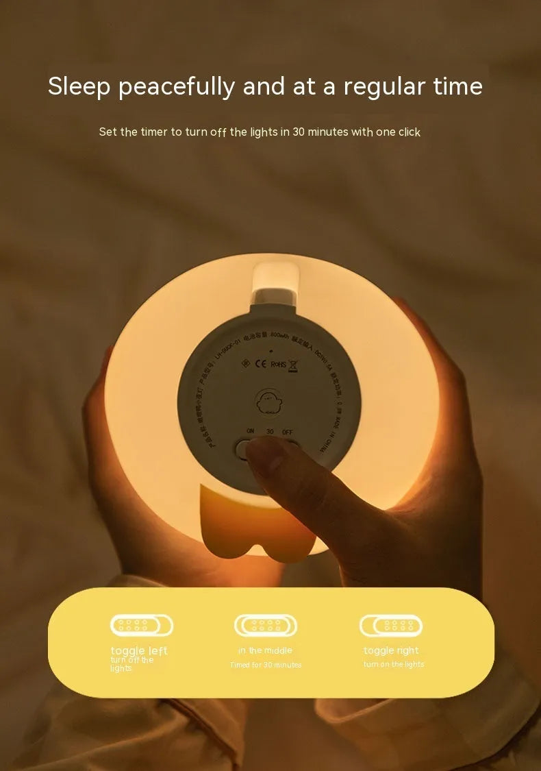 Cute duck-shaped silicone LED night lamp on a bedside table with warm light