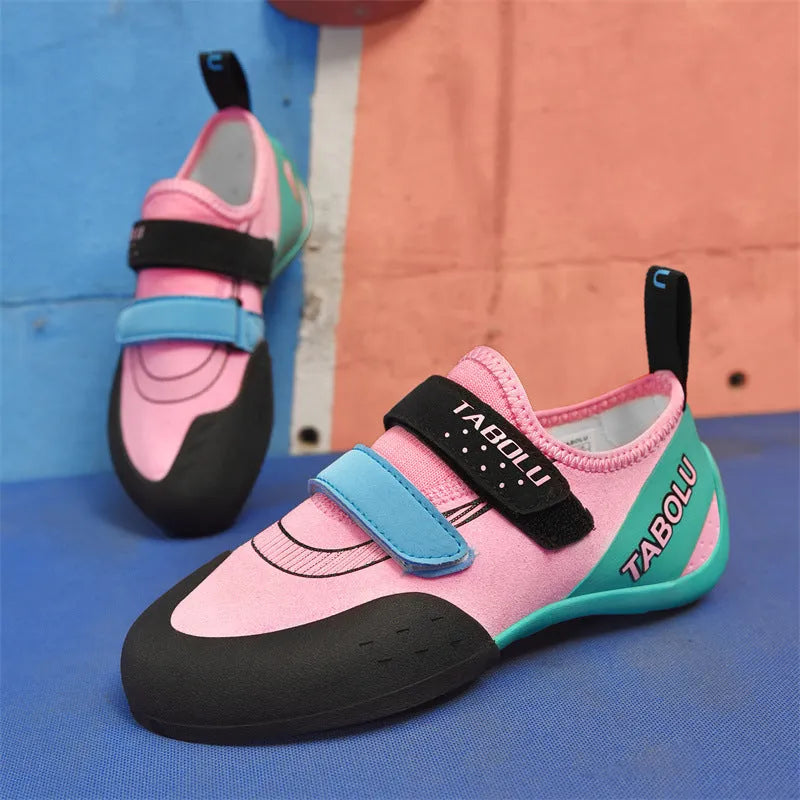 A pair of black and red rock climbing shoes with Velcro straps and a rubber sole.