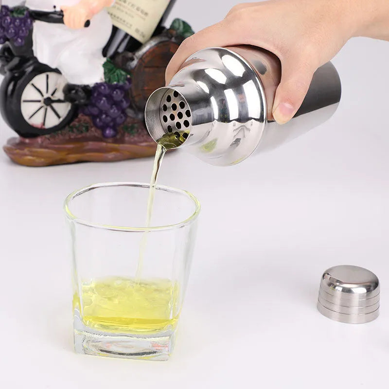 8pc stainless steel cocktail shaker set with graduated pieces on a table, various heights from 11cm to 18cm