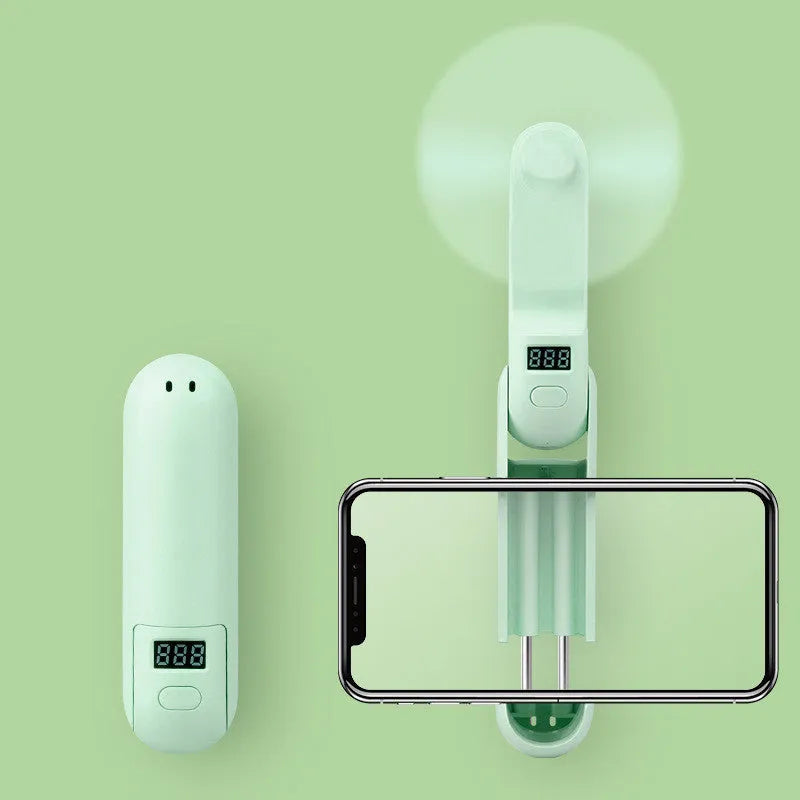 Green folding mini USB rechargeable personal desk fan with plastic blades.