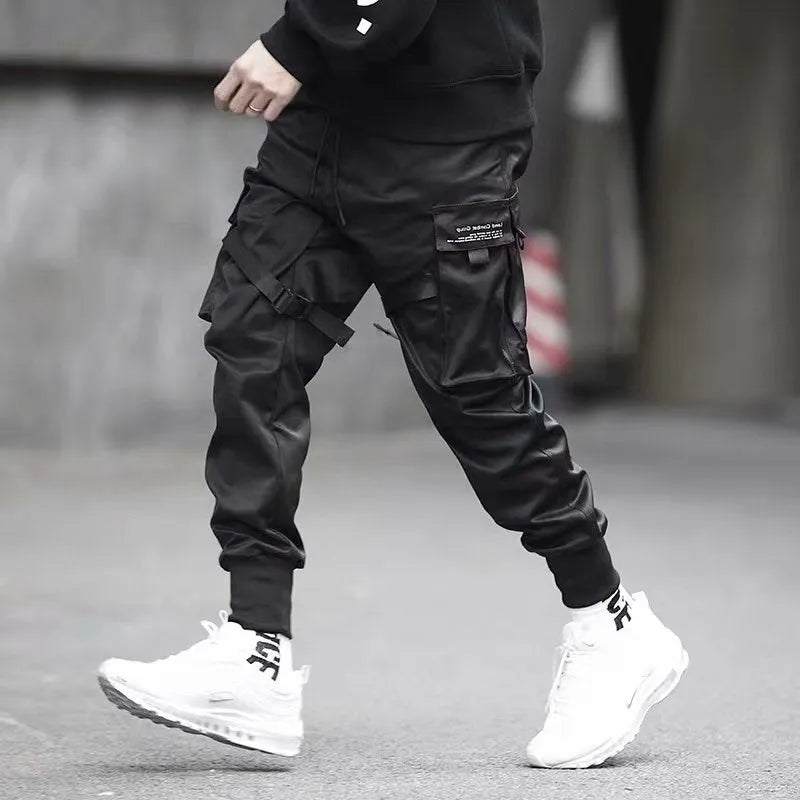 Men's black cotton harem joggers with side pockets and elastic waist, shown with drawstring and Velcro closures