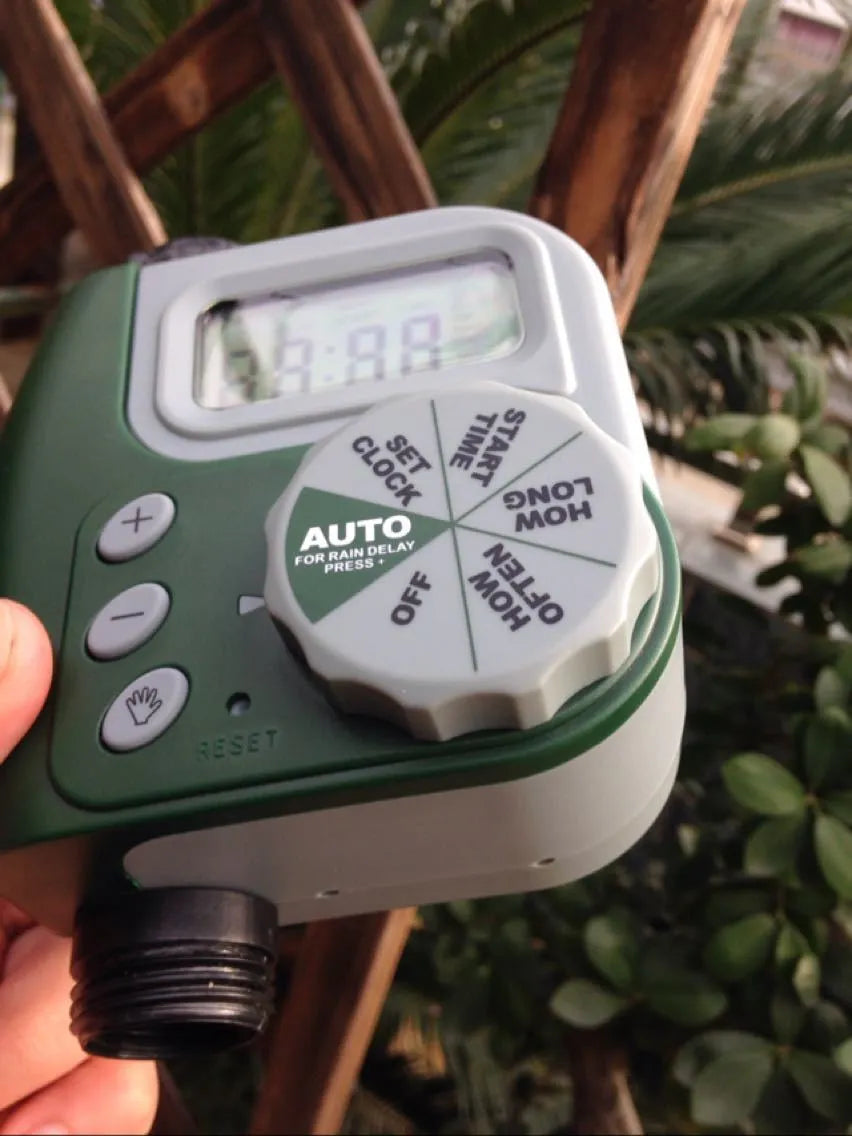 Green garden irrigation controller with LCD display and rotary dial for automatic hose timer