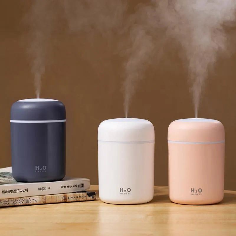 Pink USB desktop humidifier with colourful LED lights and 300ml water tank on wooden desk