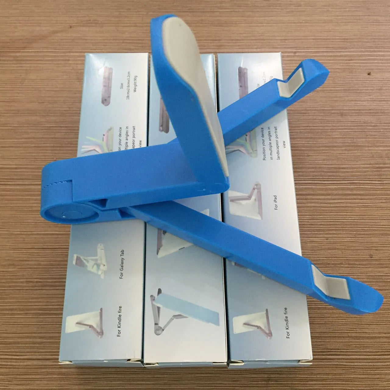 Foldable tablet holder shown in black with smartphone mounted in landscape orientation