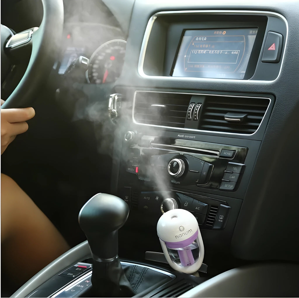 Compact blue car humidifier with rotating nozzle on car dashboard