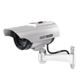 Solar-powered fake security camera in black finish mounted on a wall outdoors
