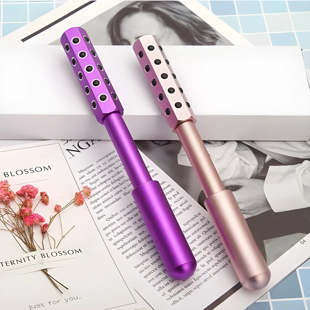 Purple handheld facial massage roller with visible germanium beads on a rotating head