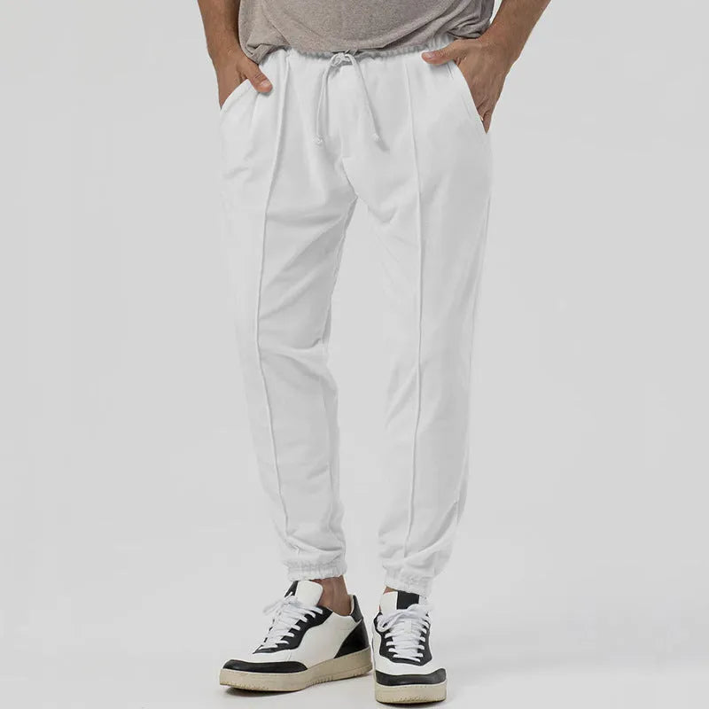 Man wearing gray straight-leg casual track sweatpants with a tapered fit and elastic waistband.