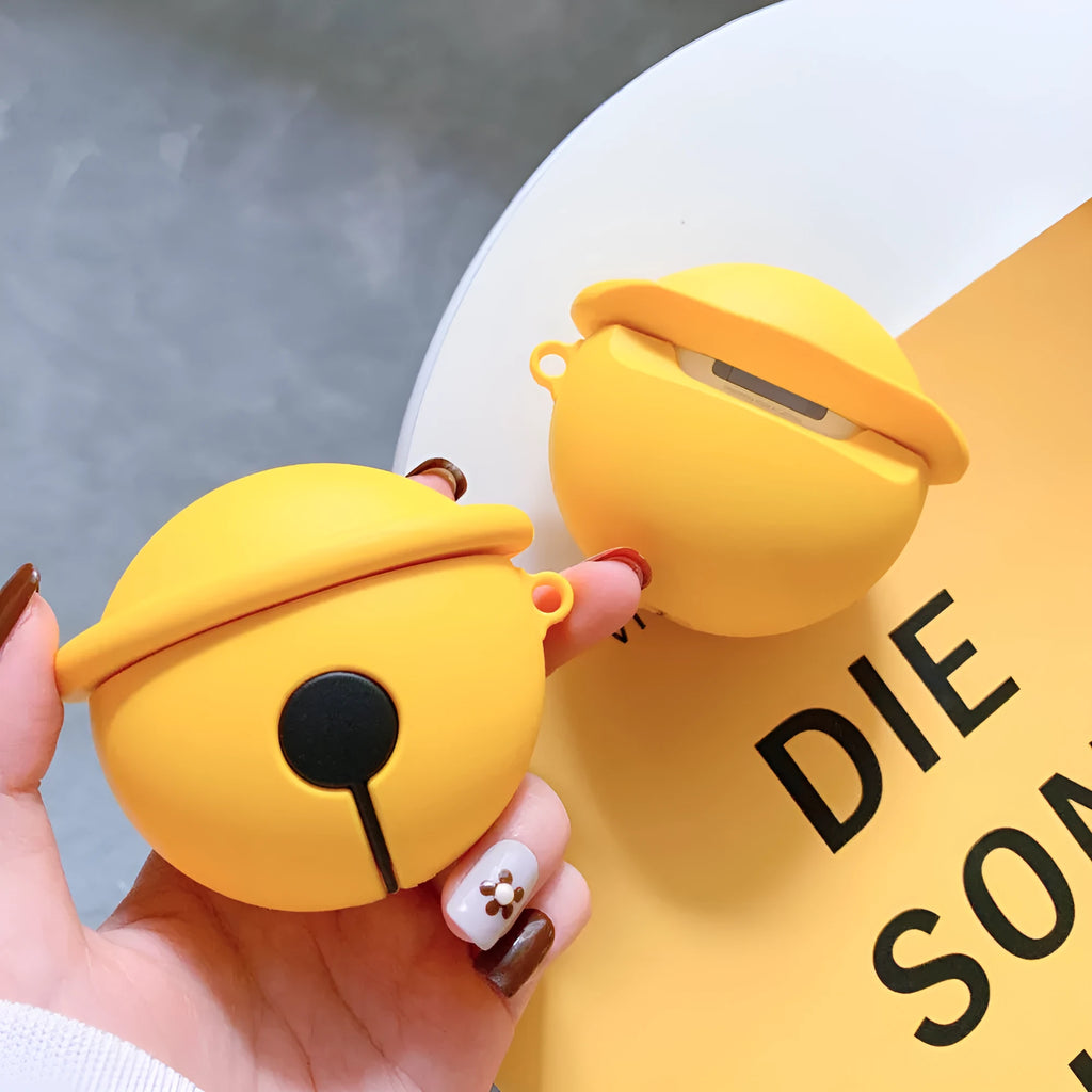 Yellow silicone AirPods case with decorative bell charm for wireless earbuds protection