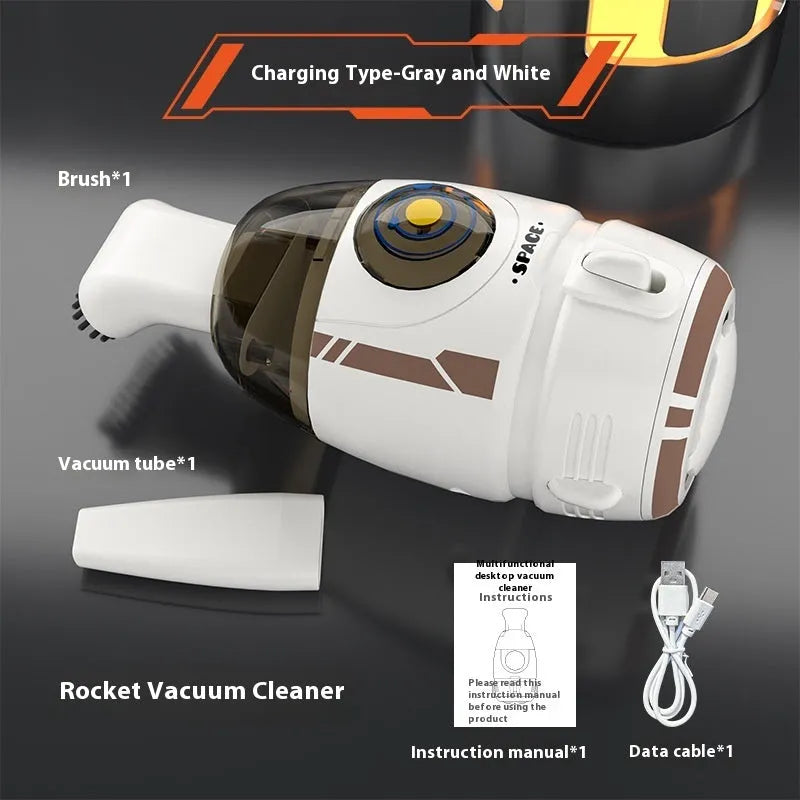 Handheld desktop vacuum cleaner in blue rocket design with USB charging cable on a wooden desk.