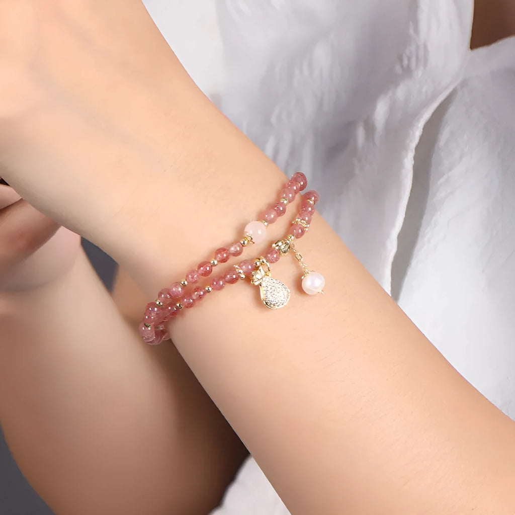 Geometric strawberry quartz crystal bracelet for women on a wrist.