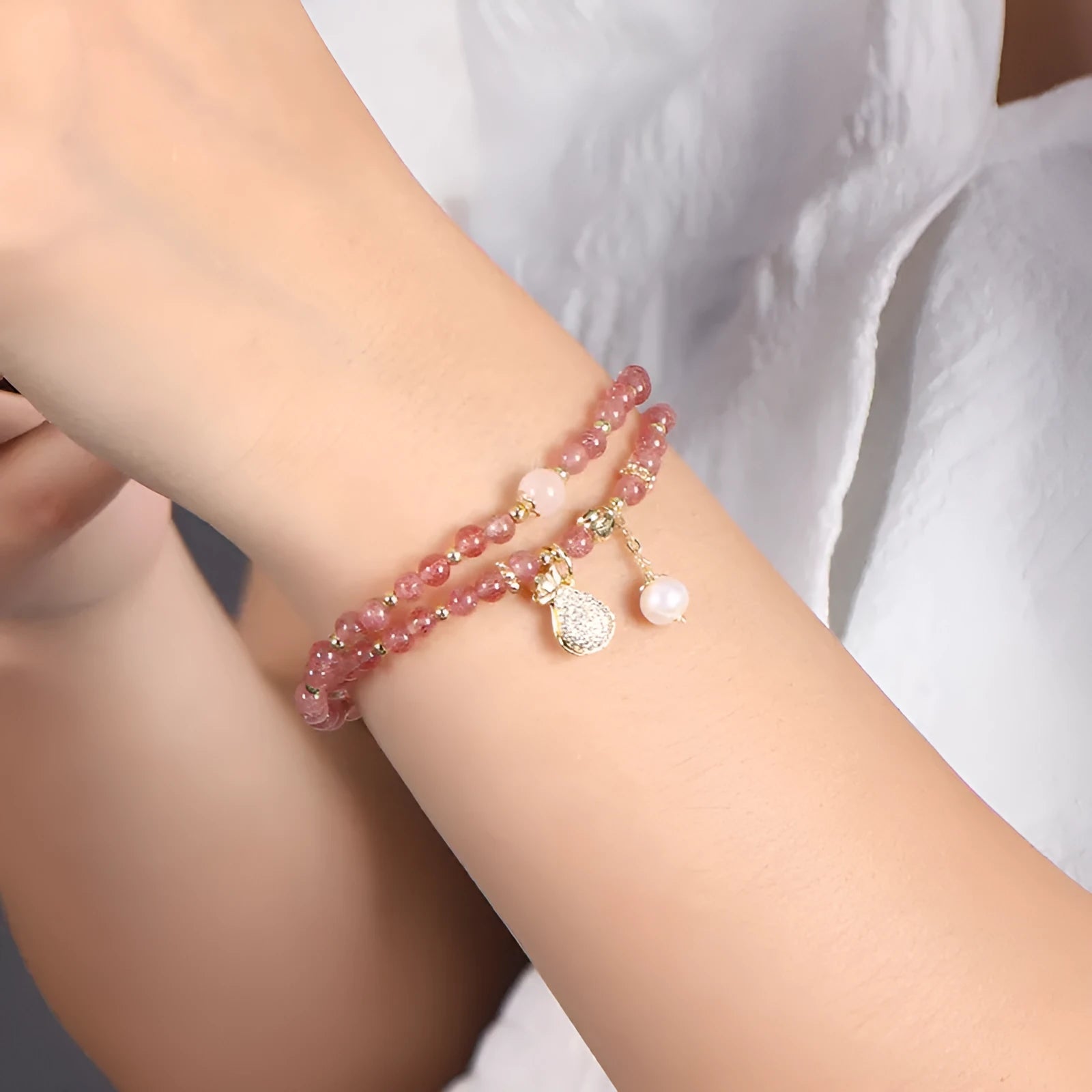 Geometric strawberry quartz crystal bracelet for women on a wrist.