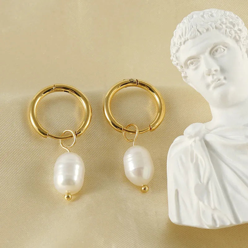 Pair of gold geometric earrings with pearl detail on titanium steel posts