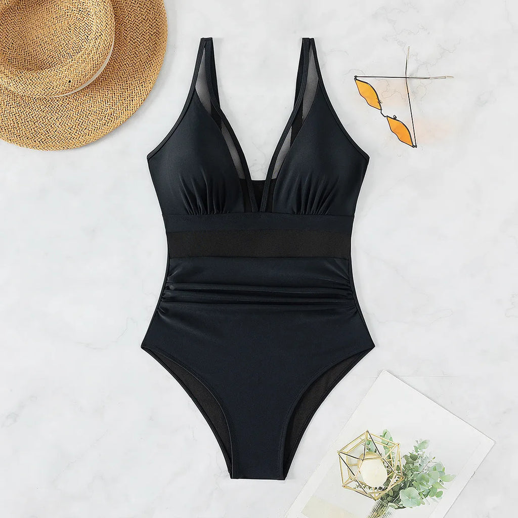 Black women's halter neck one-piece swimsuit with mesh detail and high-cut briefs.