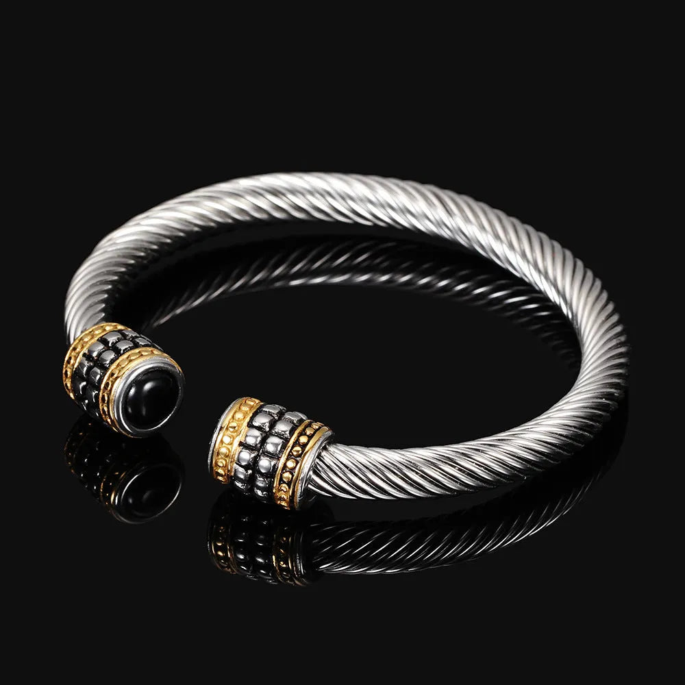 Two-tone vintage gold stainless steel bangle bracelet with black and golden finish on white background