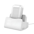 White headphone charging base stand on a desktop holding a gaming headset